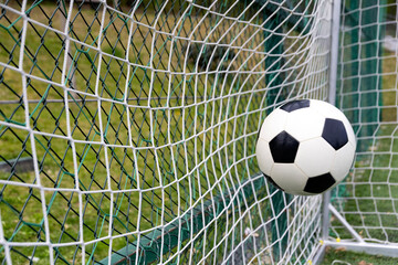 Naklejka premium Soccer ball on goal with net background