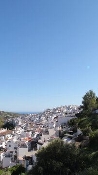 Hillside town under a clear blue sky during the day, Torrox, Spain. Tilt