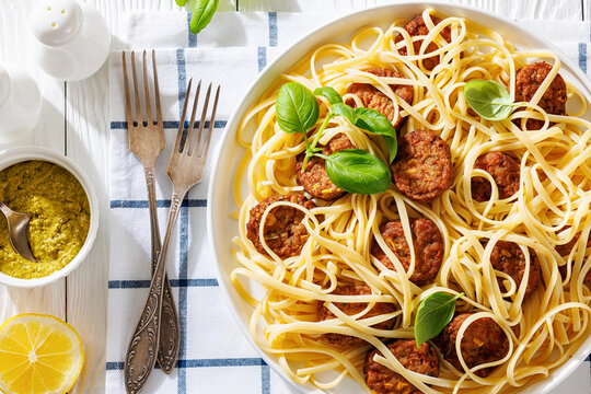 Pasta linguine with meatballs, pesto sauce, lemon