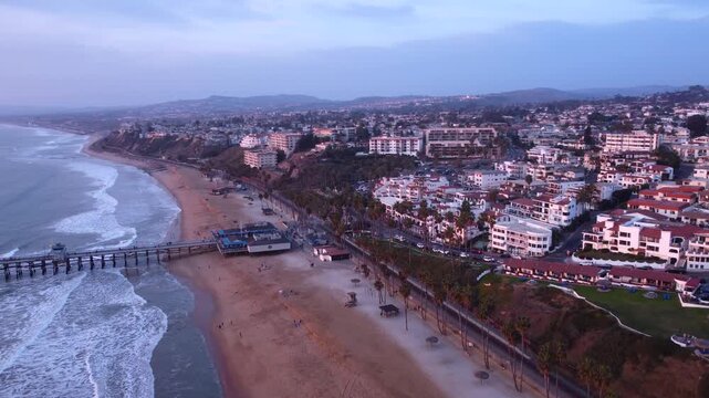 San Clemente, California. Pan to end of Long Coastal Pier Overlooking Horizon at Sunset. Looking North to Dana Point, Orange County.