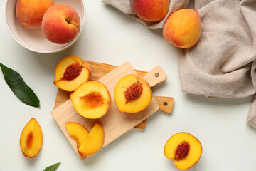 Naklejka premium Wooden board and bowl with sweet ripe peaches on white background