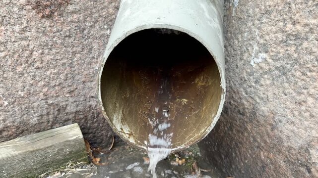 Close-up of Water Dripping from Downspout to Street in Spring Helsinki 4K