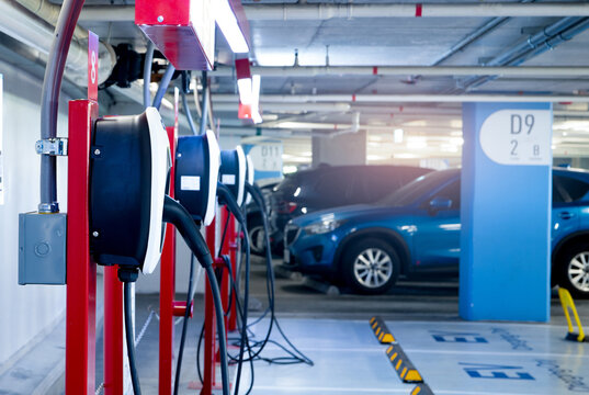 Electric car charging station for charge EV battery. Plug for electric vehicle. EV charger. Charging point at car parking lot of the mall. Clean and sustainable energy. Commercial EV charging point.