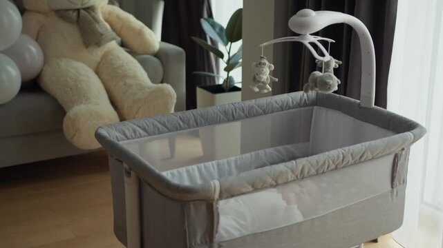 Newborn baby sleeping in bassinet with mobile overhead pastel balloons teddy bear soft toys crib nursery decor family love joy parenthood infant child parenting lifestyle cozy home peaceful moment.