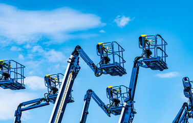 Articulated boom lift. Aerial platform lift. Telescopic boom lift against blue sky. Mobile construction crane for rent and sale. Maintenance and repair hydraulic boom lift service. Crane dealership. © Fahroni