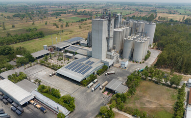 Aerial view of animal feed factory. Agricultural silos, grain storage silos, and solar panel on roofs of industrial plants. Industrial landscape. Agriculture industry. Factory with sustainable energy. © Fahroni