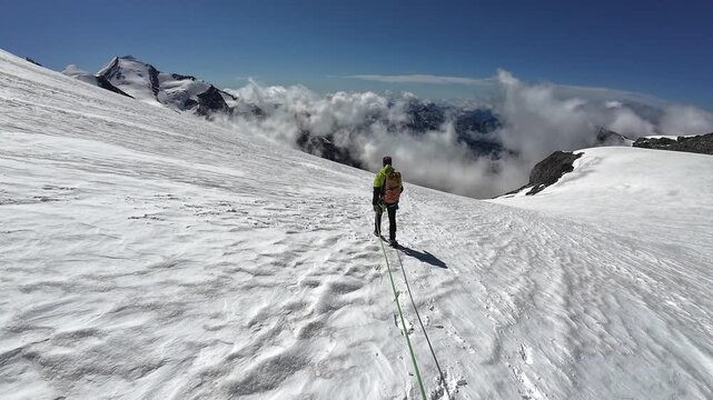 POV mountaineering in rope team with mountaineer and mountain panorama with summit Castor on the glacier in summer in Pennine Alps, Italy