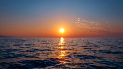 Fototapeta premium Vibrant sunrise illuminating the calm ocean surface stretching across the vast and peaceful horizon