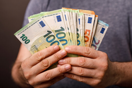 Close up of hands holding euro banknotes. Concept of finance, wealth, investment, and suc