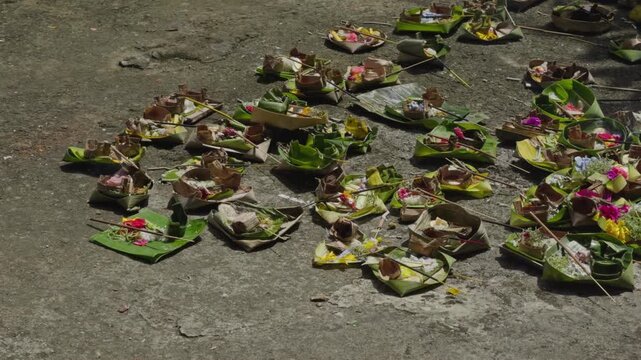 Close up of stacked Balinese canang offerings made from coconut leaves filled with flowers and incense. Represents daily Hindu prayer rituals, rich in culture, spirituality, and sacred tradition.
