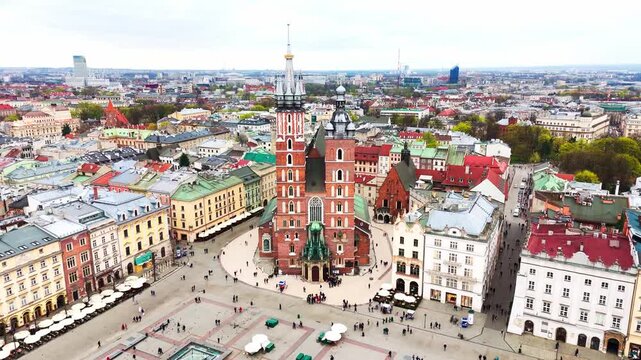 Bottom-to-top drone lift revealing the towering fa&ccedil;ade of St. Mary&rsquo;s Basilica in Krakow&rsquo;s historic Main Market Square.