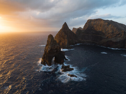 Aerial view of the dramatic rock formations and steep cliffs of Ponta de Sao Lourenco rising from the Atlantic Ocean under a golden sunset sky Canical, Madeira, Portugal.