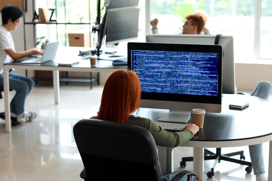 Female programmer working in office, back view