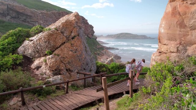 Mom and twin girls hike along boardwalk at The Gap of Robberg Hiking Trail