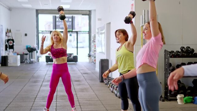 Determined people training with dumbbells in a fitness class