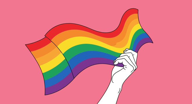 Hand holding rainbow flag waving against pink background, LGBTQ pride symbol