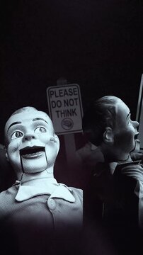 A group of faceless spinning mannequins and political statements contained on street signs on an endless loop.
