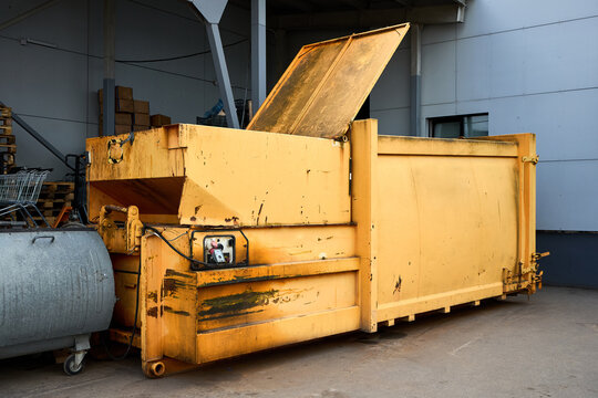 Press Container waste Compactor machine for Reducing Volume in yard of large hypermarket mall. Press Container Compactor for Reducing Volume of Municipal and Industrial Waste. Waste recycling concept.