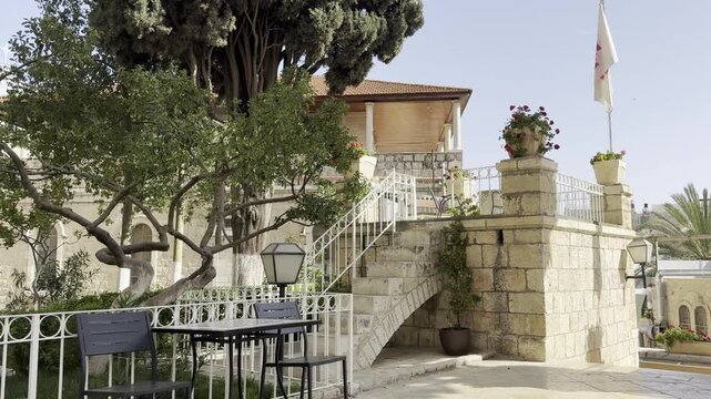 Jerusalem, Israel, April 17, 2026. View of a portico and elevated terrace with staircases in the courtyard of the Austrian Hospice in the Old City, with the Austrian flag visible.
