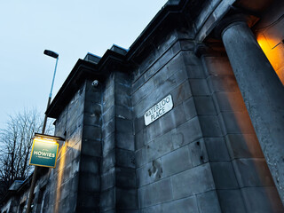 Obraz premium Evening view of Waterloo Place building facade and Howies restaurant sign in Edinburgh, Scotland, UK with moody blue urban architecture and classical stone columns