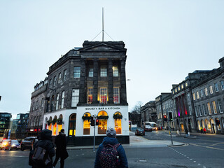 Obraz premium Evening street scene outside Society Bar and Kitchen in Edinburgh, Scotland, UK with pedestrians, traffic and Georgian architecture