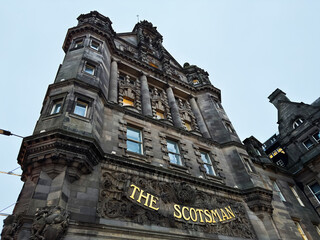 Obraz premium The Scotsman building facade in Edinburgh, Scotland, UK showcasing historic stone architecture, ornate carving and grand columns on a dramatic urban city street elevation