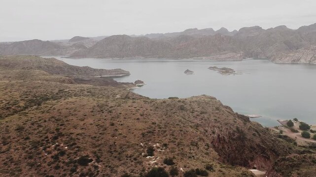 Aerial view of lake Los Reyunos in Mendoza, Argentina, on a dark, misty day.