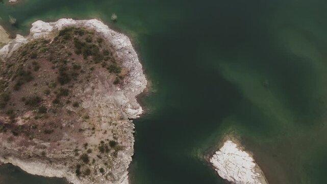 Aerial view of lake Los Reyunos in Mendoza, Argentina, on a dark, overcast day.