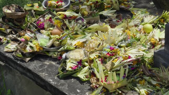 Close up of stacked Balinese canang offerings made from coconut leaves filled with flowers and incense. Represents daily Hindu prayer rituals, rich in culture, spirituality, and sacred tradition.
