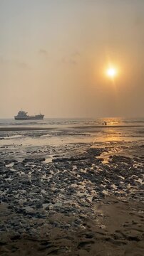 Golden Sunset over Parki Sea Beach with Cargo Ships and Muddy Shoreline - Chittagong, Bangladesh