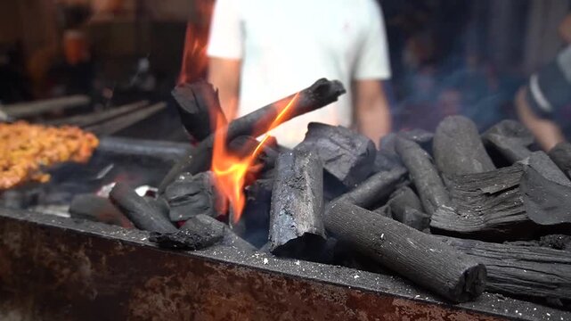 Charcoal flames burning bright with intense heat and contrast, fire energy concept