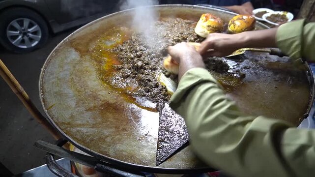 Kaleji meat cooking with buns on hot tawa, rich street flavor, street meal concept