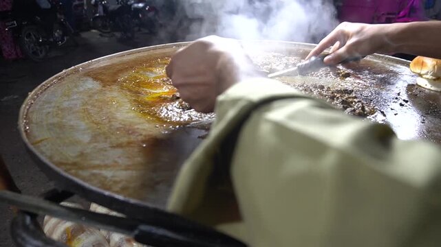 Kaleji sizzling on griddle with steam and intense street food action, spicy food concept