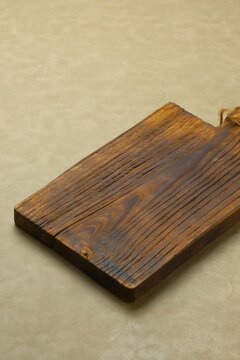 Empty rustic wooden chopping board on brown background, made from teak wood. Telenan kayu jati