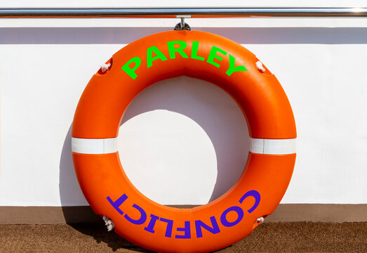 Parley instead conflict symbol. Concept words Parley and Conflict on beautiful orange lifebuoy. Beautiful white ship board background. Social and parley instead conflict concept. Copy space.