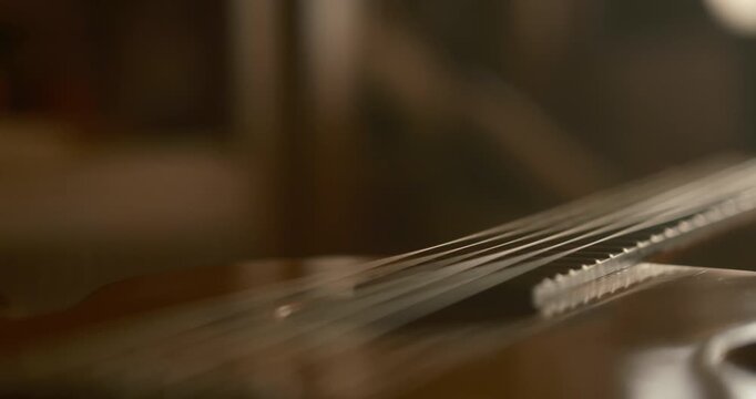 cozy home interior where a guitar rests gently on a bed, camera moves slowly and smoothly, gliding across the strings and along the neck of the guitar,  cat sleeps peacefully