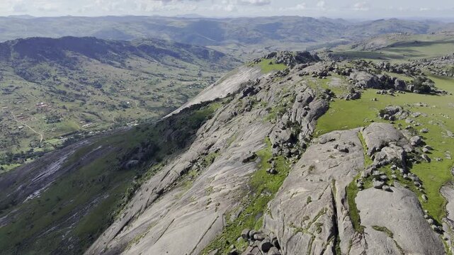 Drone flies high above along northwest face of cliff on a sunny day at Sibebe Rock near Mbabane, Eswatini