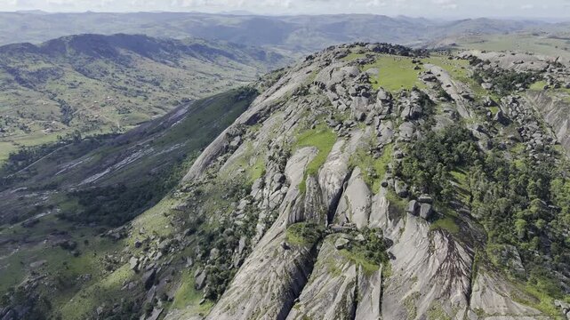 Drone flies north along summit half covered in shade and sunlight on a sunny afternoon at Sibebe Rock near Mbabane, Eswatini