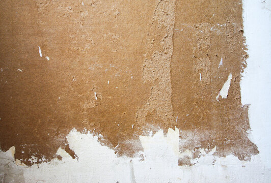Wall with applied filler and plaster showing irregular stains and textures. Scene emphasizes construction detail and surface finishing stage.