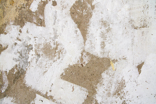 Close-up of drywall repair with filler spots and uneven plaster surface. Scene reflects construction process and surface treatment before painting.