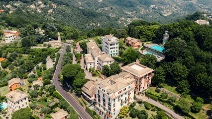 Aerial view of camogli, showing colorful houses, swimming pool, and lush vegetation © Doralin