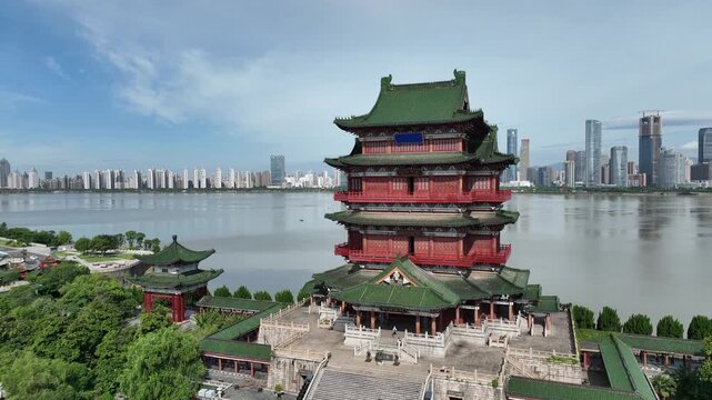 Aerial drone video of Prince Teng historic building majestically standing tall with its unique Chinese architecture, looking over the modern city skyline and river in Nanchang, China