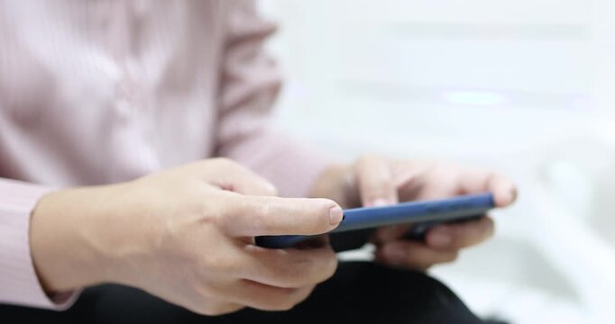 Woman playing a mobile game on a smartphone, tapping the screen. Ideal for gaming, entertainment, technology, and digital lifestyle concepts, close-up