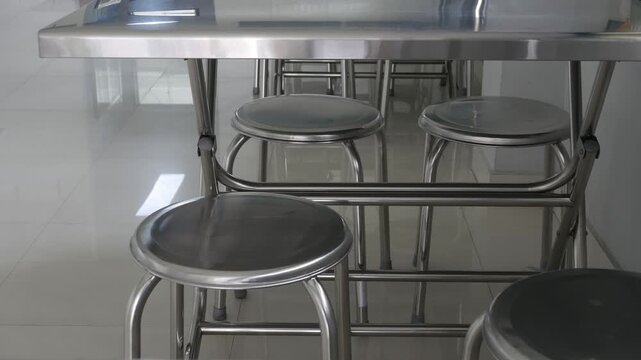 stainless steel round stools and folding tables in a clean modern Asian restaurant