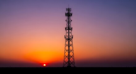 Fototapeta premium Silhouette of a cell tower against a sunset sky with orange and purple hues telecommunication tower silhouette communication technology wireless broadcasting twilight