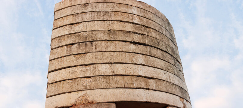 Minimalist low angle view of concrete blocks making the tower crane counterweight against a bright cloudy sky with copy space.
