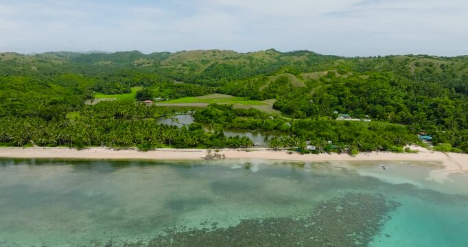 Tropical landscape of beach with white sand and turquoise water over reefs. Santa Fe, Tablas, Romblon. Philippines.