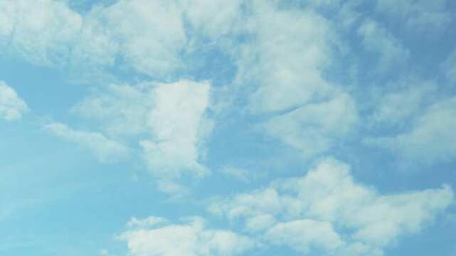 Spring blue sky flying white fluffy clouds in sunlight air plane window view, time lapse, motion. Azure skyscraper firmament heaven atmosphere and white puffy clouds 4K. 