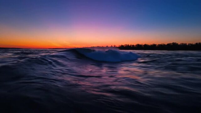 Mesmerizing ocean wave breaking during a colorful sunset at dusk with the sky's vibrant orange and purple hues
