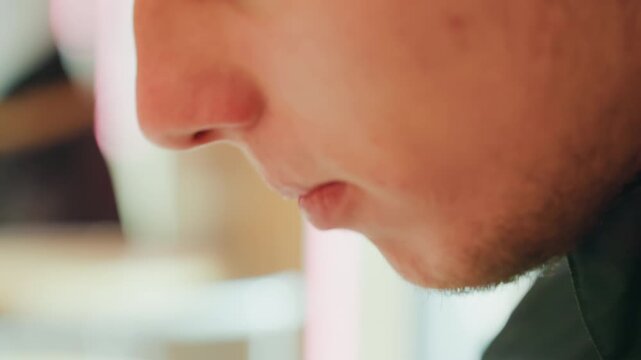 Closeup profile young man eating quietly in soft neon cafe light, tight shots of lips chin and stubble, slow mouth movements, delicate fork and spoon detail, warm pastel bokeh, introspective mood